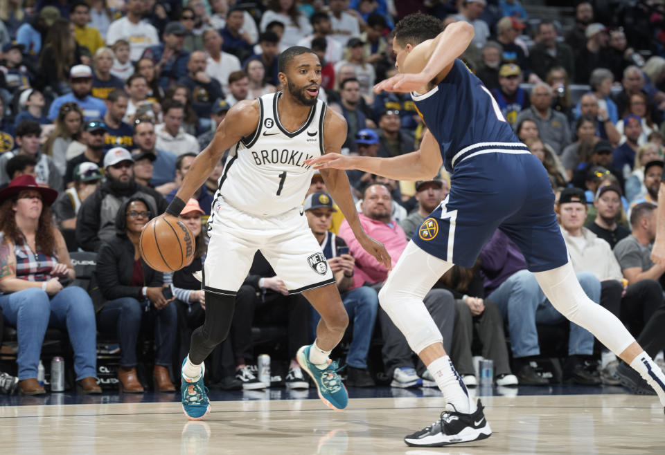 Brooklyn Nets forward Mikal Bridges, back, looks to drive to the rim as Denver Nuggets forward Michael Porter Jr. defends in the first half of an NBA basketball game, Sunday, March 12, 2023, in Denver. (AP Photo/David Zalubowski)