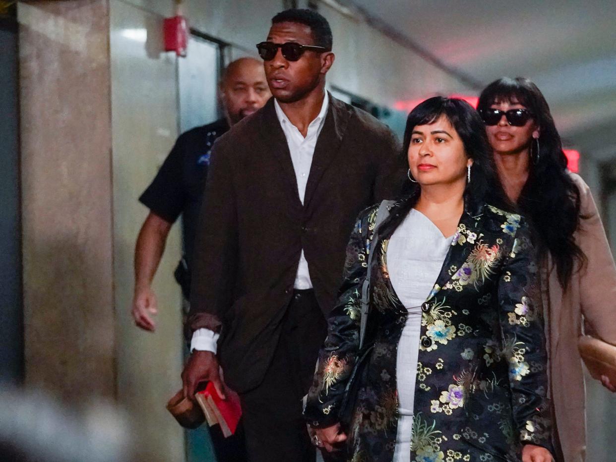 Marvel actor Jonathan Majors leaves Manhattan Criminal Court with attorney Priya Chaudhry, center, and girlfriend Meagan Good.