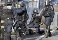 Riot police officers detain a protester during a demonstration Saturday, Feb.16, 2019 in Paris. Yellow vest protesters are holding scattered demonstrations around Paris and the rest of France amid waning support for their movement. (AP Photo/Thibault Camus)