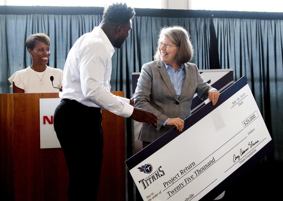 Project Return's Bettie Kirkland smiles with Delanie Walker and Tina Tuggle after receiving a check for Project Return at Nissan Stadium Tuesday, July 30, 2019, in Nashville, Tenn. 