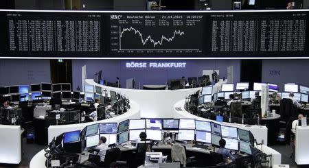 Traders are pictured at their desks in front of the DAX board at the Frankfurt stock exchange April 21, 2015. REUTERS/Staff/remote