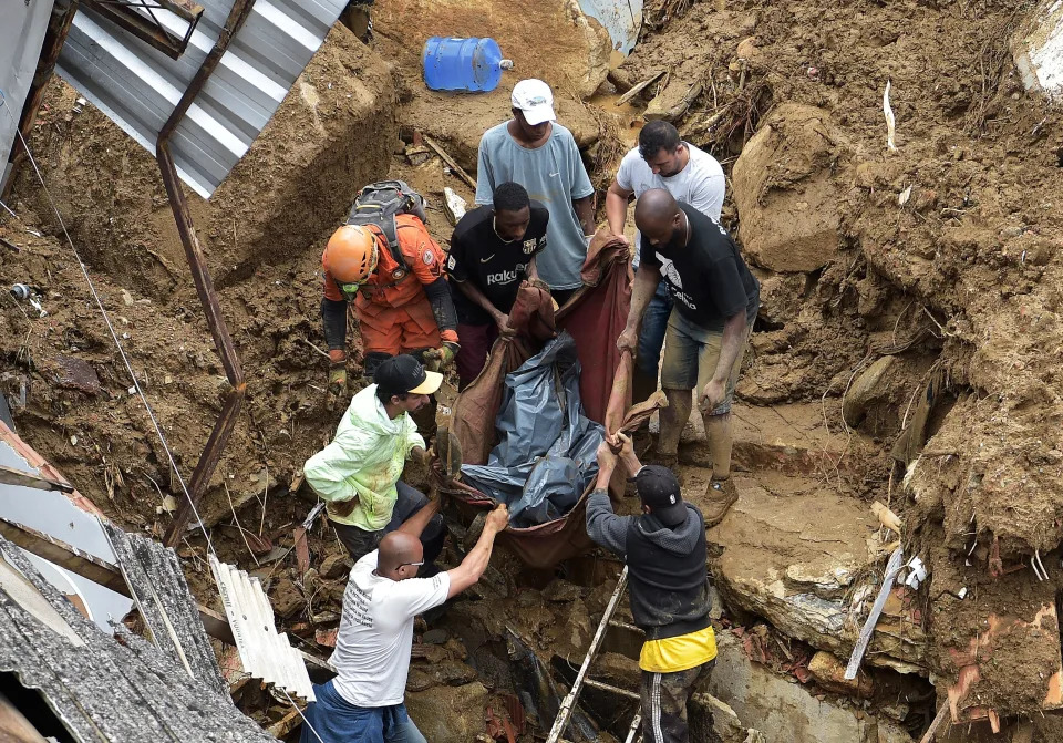 Pessoas carregam um corpo para fora dos escombros ap&#xf3;s um deslizamento de terra em Petr&#xf3;polis, Brasil, em 16 de fevereiro de 2022.