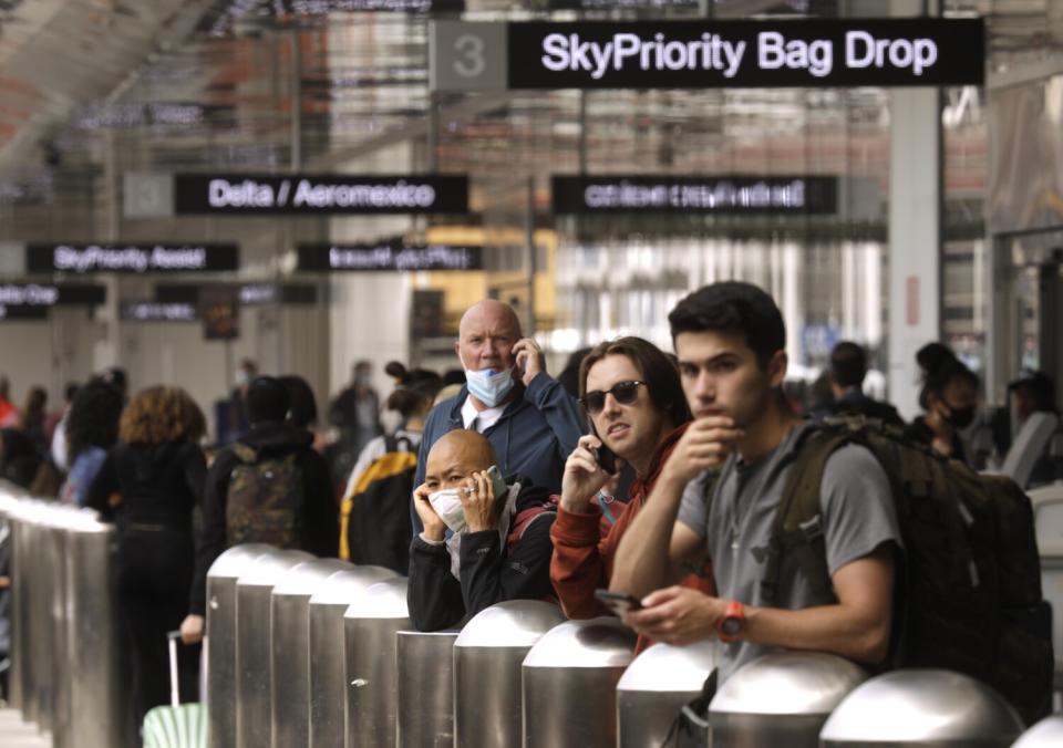 Travelers wait for their rides at the beginning of the Memorial Day weekend at the Los Angeles International Airport.