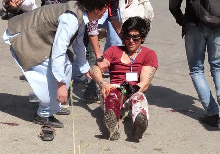 People help a wounded man after a blast during a demonstration in Kabul, Afghanistan July 23, 2016. REUTERS/Stringer