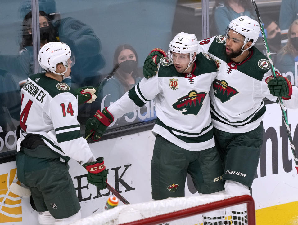 Minnesota Wild center Nick Bonino, center, celebrates with teammates Jordan Greenway (18) and Joel Eriksson Ek (14) after scoring a goal against the San Jose Sharks during the first period of an NHL hockey game in San Jose, Calif., Monday, March 29, 2021. (AP Photo/Tony Avelar)