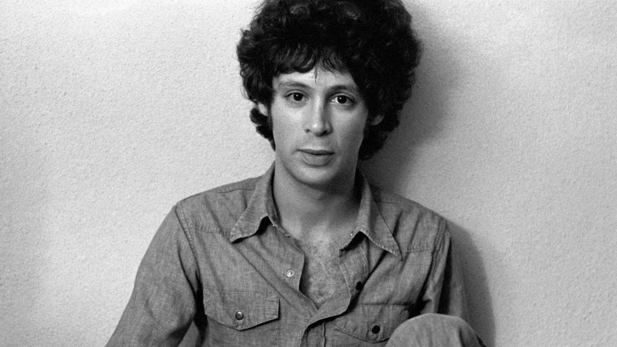 eric carmen sitting against a wall for a black and white portrait photo