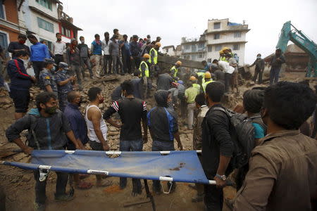 Rescue workers search for bodies as a stretcher is kept ready after an earthquake hit, in Kathmandu, Nepal April 25, 2015. REUTERS/Navesh Chitrakar