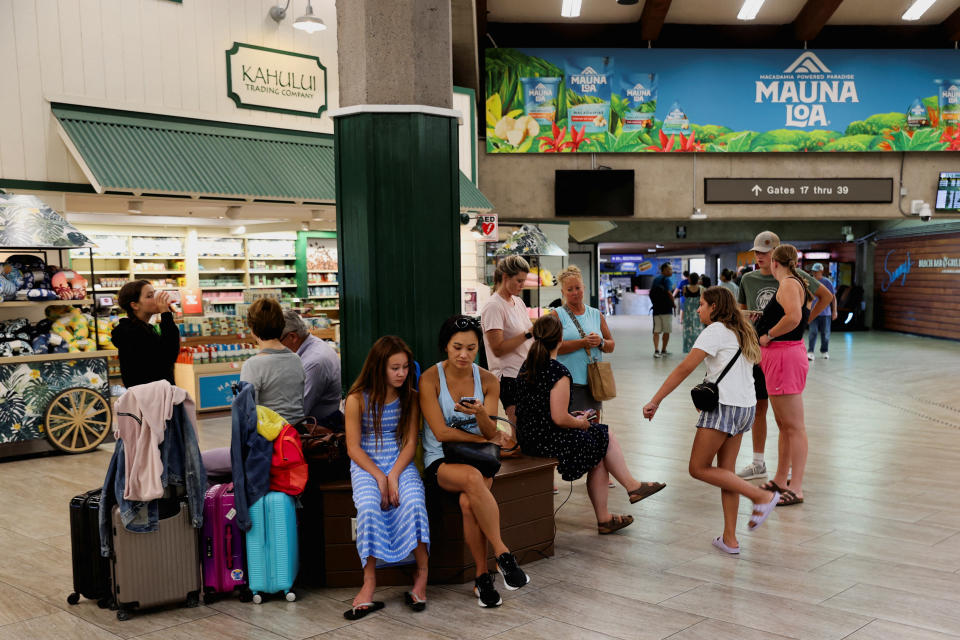 A crowd of tourists wait for flights out of Maui at the airport.