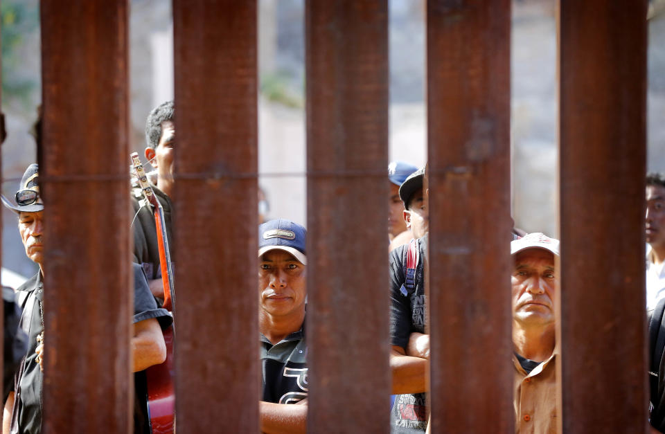 People gather on the Mexican side of the international border to hear Boston Archdiocese Cardinal Sean O'Malley lead mass, Tuesday, April 1, 2014, along the international border wall in Nogales, Ariz. A delegation of Roman Catholic leaders celebrated Mass along the U.S.-Mexico border to raise awareness about immigration and to pray for policy changes. (AP Photo/Matt York)