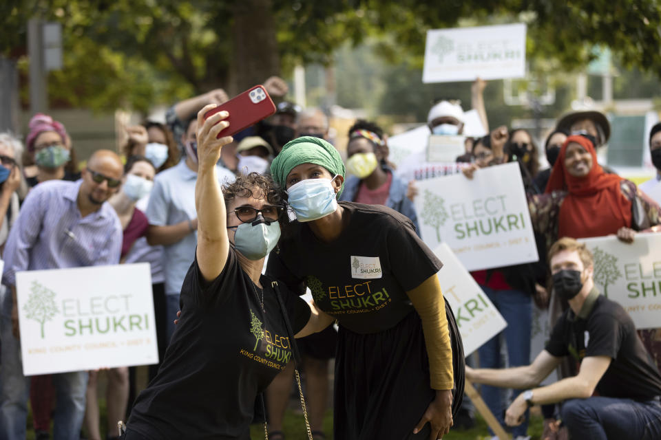 Shukri Olow, center-right, a Muslim woman who is running for King County Council District 5, poses for a selfie photo with supporter Samia El-Moslimany, center-left, Saturday, Aug. 14, 2021, at a rally at a park in Renton, Wash., south of Seattle. Muslim Americans in their 20s and 30s who grew up amid the aftershocks of the Sept. 11, 2001 terrorist attacks came of age in a world not necessarily attuned to their interests, their happiness and their well-being. Olow says the aftermath of the attacks has helped motivate her to become a community organizer and to run for office in Washington state. (AP Photo/Karen Ducey)