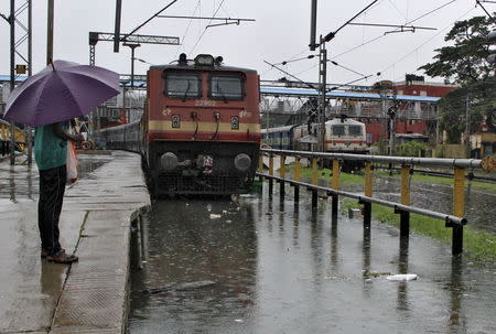 A man stands next to a flooded railway track as it rains in Chennai, India, December 2, 2015. REUTERS/Stringer