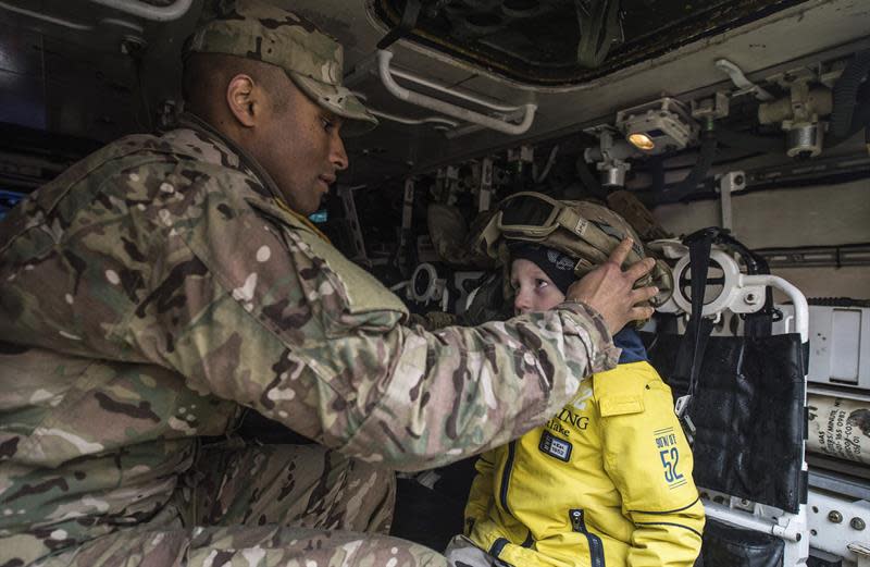 Un soldado estadounidense prueba un casco militar a un niño con motivo de la parada de un convoy del Ejército de EEUU en Praga (República Checa). EFE/Filip Singer