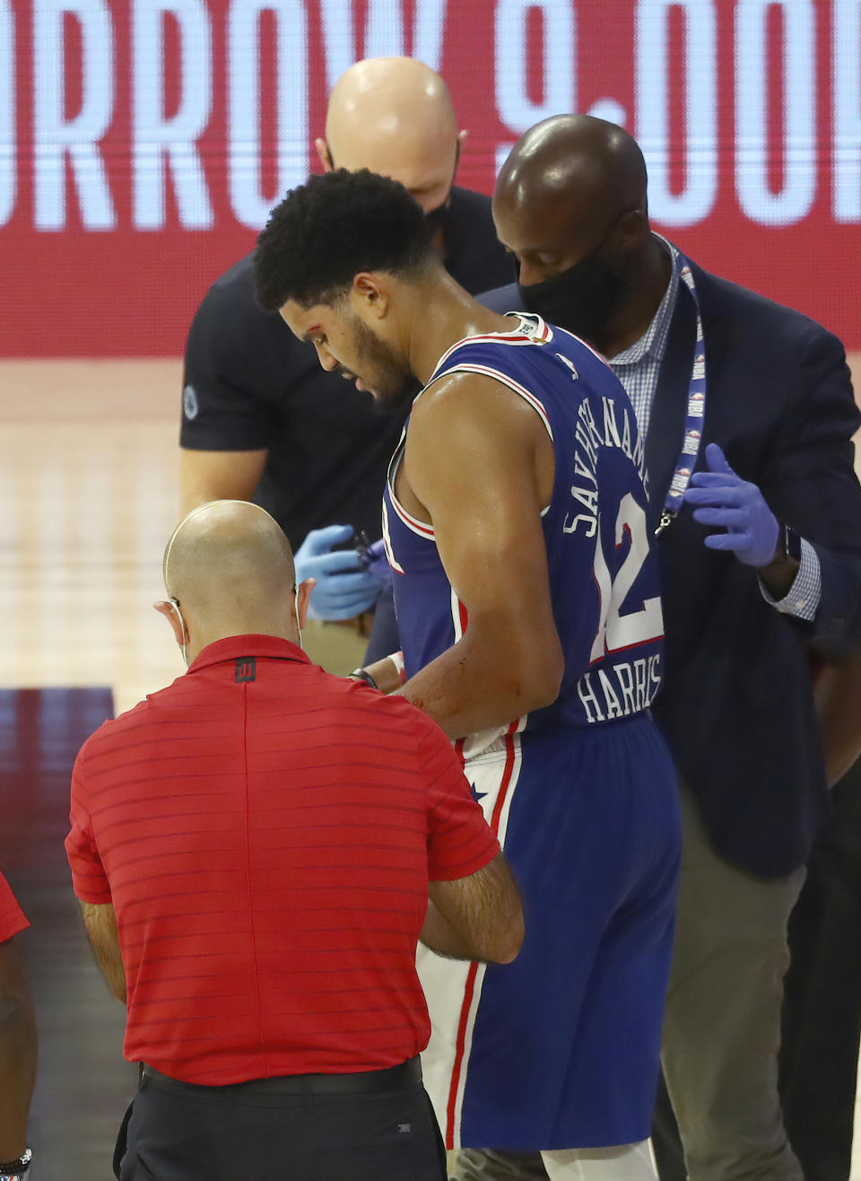 Philadelphia 76ers forward Tobias Harris (12) is attended to after hitting his head against the Boston Celtics during the third quarter of Game 4 of an NBA basketball first-round playoff series, Sunday, Aug. 23, 2020, in Lake Buena Vista, Fla. (Kim Klement/Pool Photo via AP)