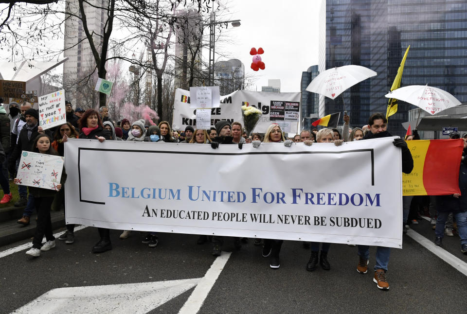 Demonstrators march during a protest against coronavirus measures in Brussels, Belgium, Sunday, Dec. 5, 2021. Kindergartens and primary schools will now close for the holiday season a week early, on Dec. 20, children must wear masks from the age of 6. and attendance at indoor events is limited to a maximum of 200 people. (AP Photo/Geert Vanden Wijngaert)