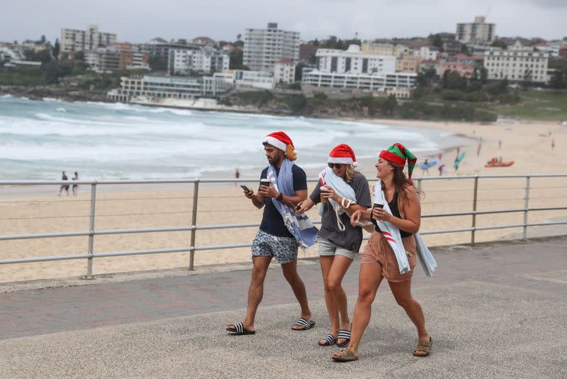 People wear Santa hats on Christmas Day at Bondi Beach in Sydney