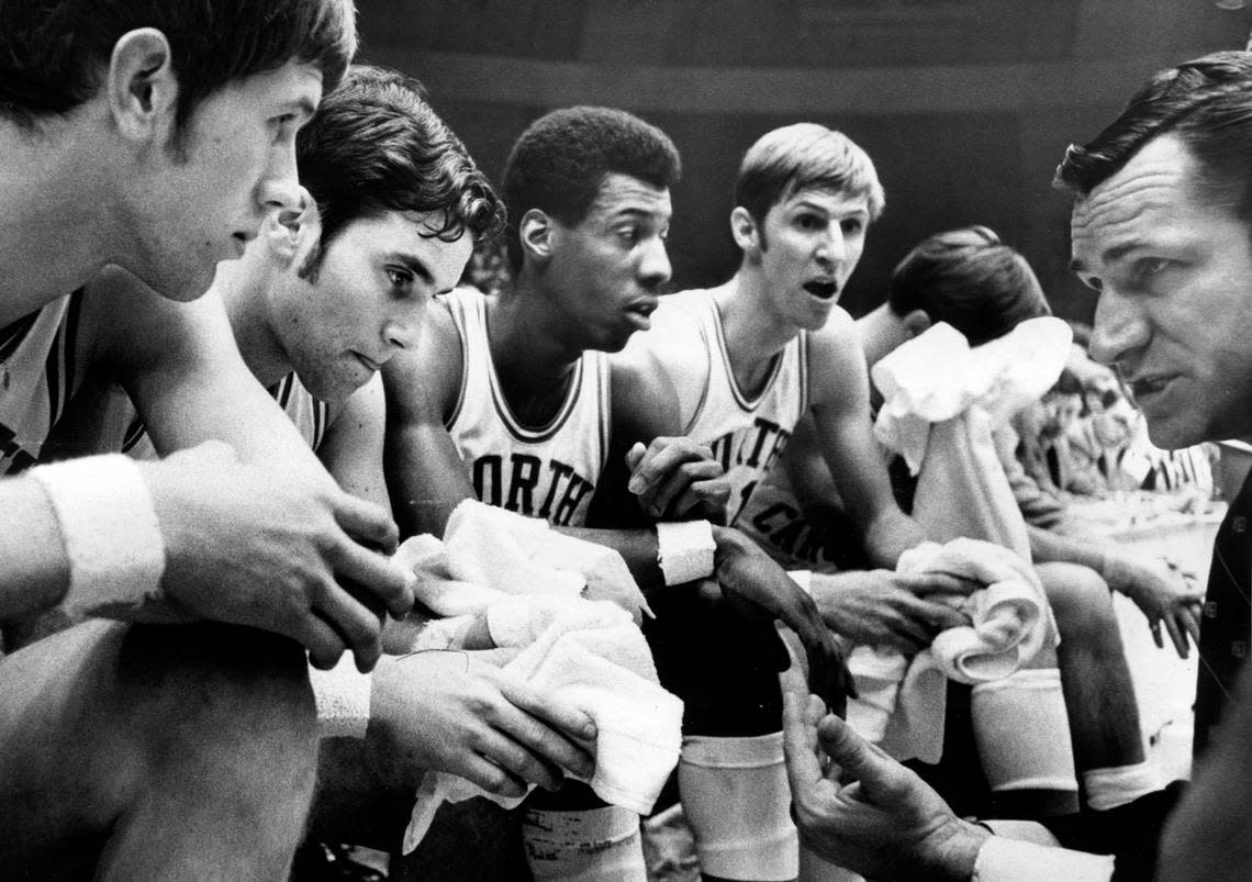 UNC coach Dean Smith (right) gives instructions to his players including Charlie Scott (center) during a game in the 1969 ACC Tournament.