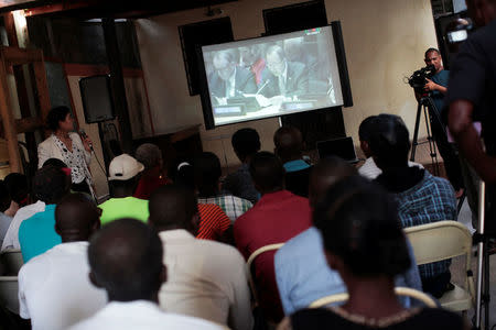 Haitians watch a broadcast of outgoing United Nations Secretary-General Ban Ki-moon's apology to the people of Haiti for the world body's role in a deadly cholera outbreak, on a screen at the Office of International Lawyers in Port-au-Prince, Haiti, December 1, 2016. REUTERS/Andres Martinez Casares