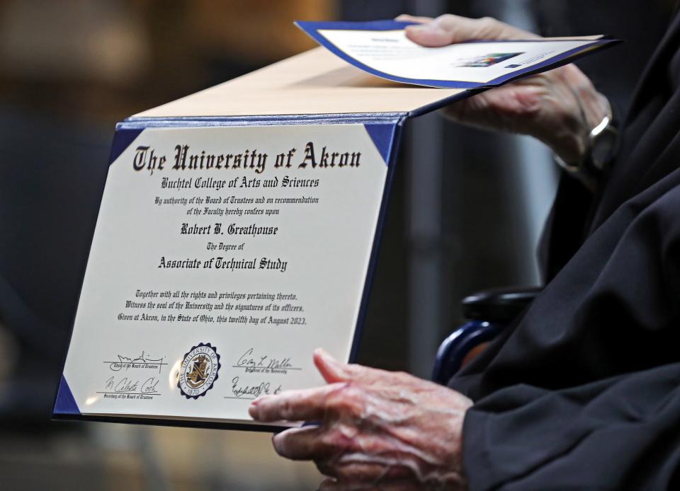 Robert Greathouse, 93, shows off the degree that he received Monday, 30 years after taking his last class at the University of Akron.