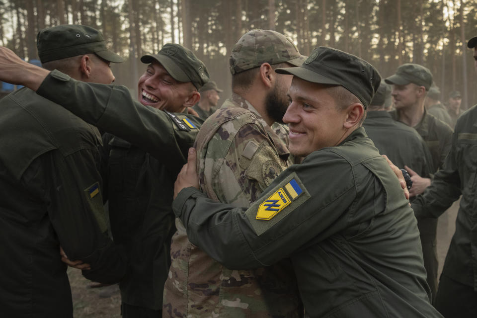 Newly recruited soldiers hug each other as they celebrate the end of their training at a military base close to Kyiv, Ukraine, Monday, Sept. 25, 2023. As the third year of war begins, the most sensitive and urgent challenge pressing on Ukraine is whether it can muster enough new soldiers to repel – and eventually drive out – an enemy with far more fighters at its disposal. (AP Photo/Efrem Lukatsky)