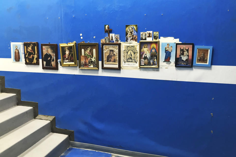 Saints icons are displayed on a wall before the stairway leading the field entrance of the San Paolo's stadium in Naples, Italy Tuesday, Sept. 17, 2019. Before he climbed the steps and emerged before the crowd, Maradona used to pray to the Madonna di Pompei and kiss the prayer card. (AP Photo/Andrew Dampf)