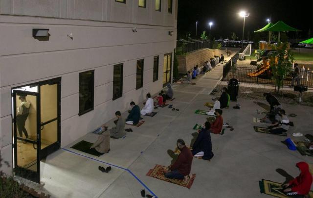 Muslims pray on the evening of Saturday, May 8, in an overflow area outside the Islamic Center of Johnson County on the 27th Night of Ramadan in Overland Park.  Safety procedures including social distancing and temperature checks were in place. The event was not held last year due to the pandemic.