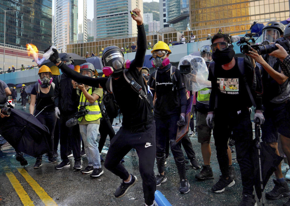 An anti-government protester throws a Molotov cocktail during a demonstration near Central Government Complex in Hong Kong, Sunday, Sept. 15, 2019. Police fired a water cannon and tear gas at protesters who lobbed Molotov cocktails outside the Hong Kong government office complex Sunday, as violence flared anew after thousands of pro-democracy supporters marched through downtown in defiance of a police ban. (AP Photo/Vincent Yu)