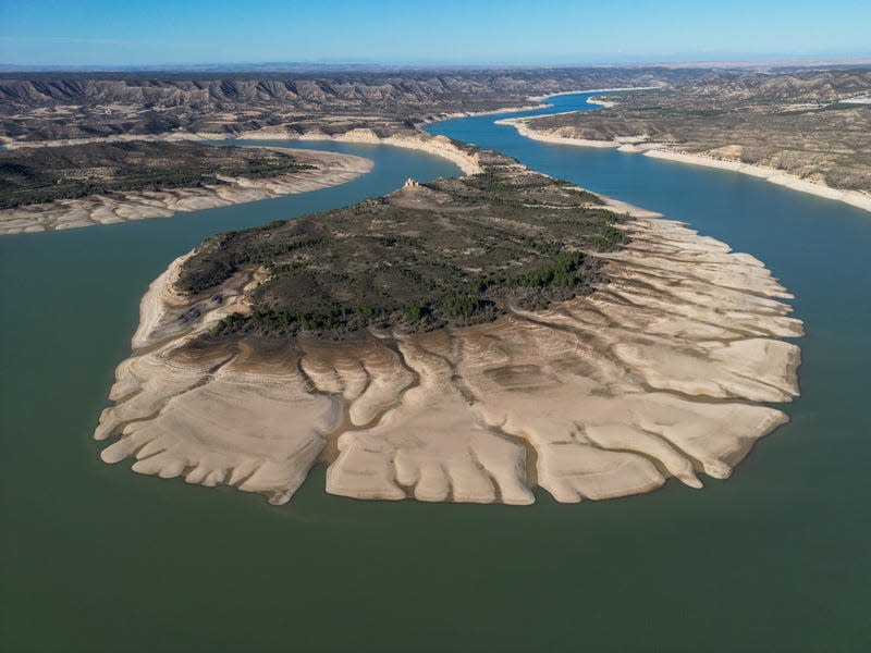 An island on the reservoir surrounded by exposed land from low water levels.