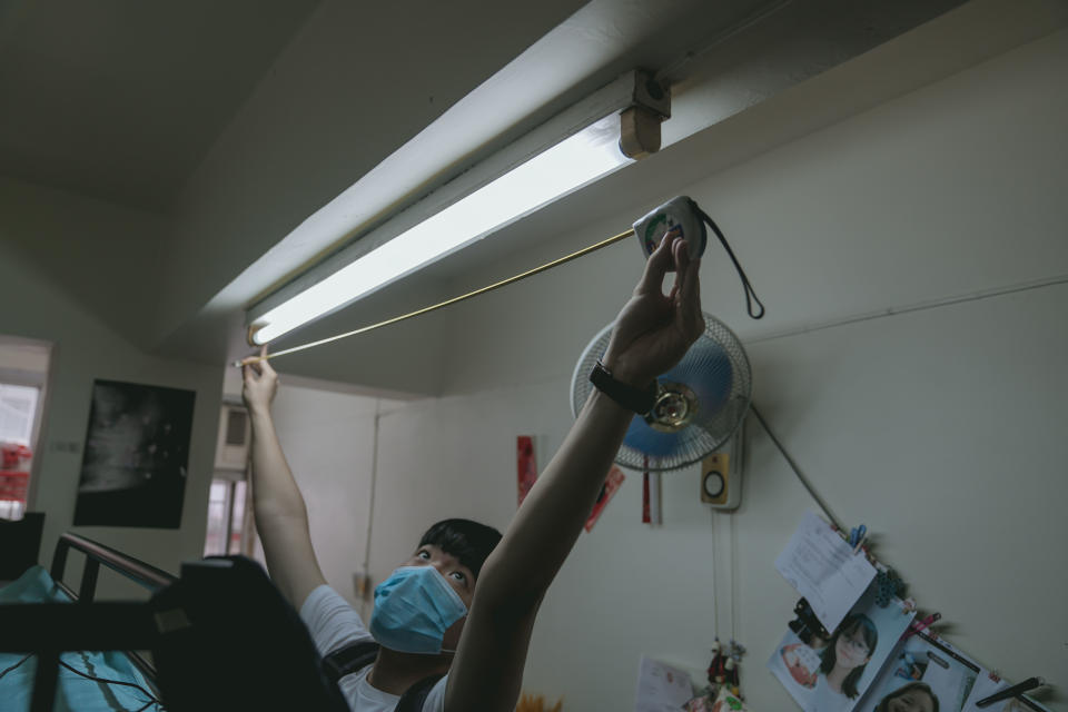 低碳想創坊團隊測量劏房家庭的燈管尺寸後，安排師傅上門更換成節能的LED燈。
