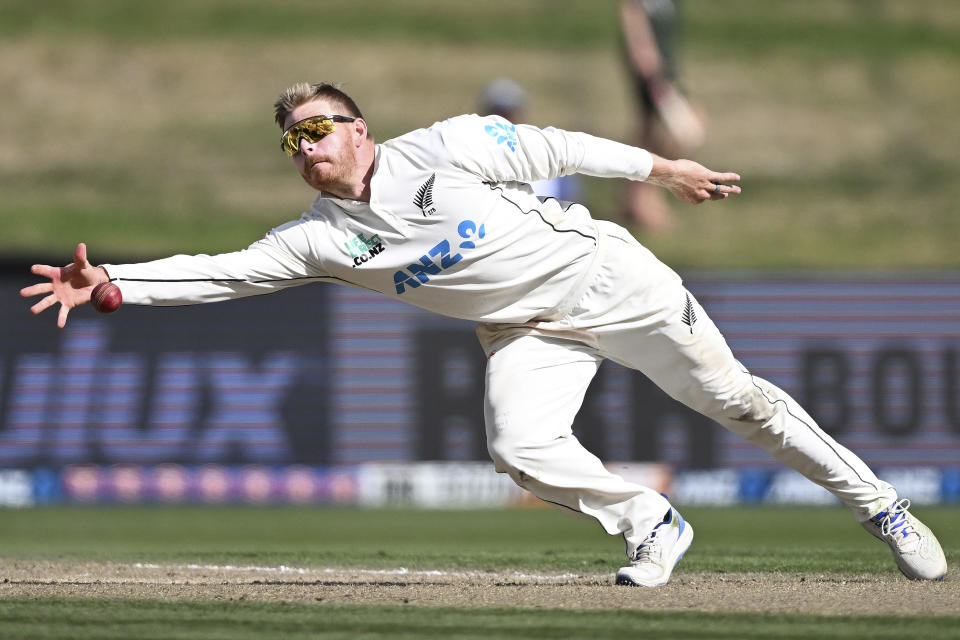 New Zealand's Glenn Phillips dives as he fields the ball off his own bowling to South Africa on the third day of their cricket test in Hamilton, New Zealand. Thursday, Feb. 15, 2024. (Andrew Cornaga/Photosport via AP)