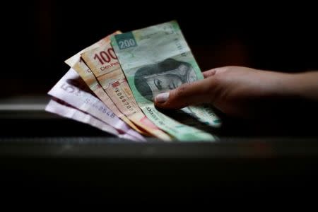 FILE PHOTO: A man holds Mexican pesos in Mexico City, Mexico on August 3, 2017. REUTERS/Edgard Garrido/File Photo