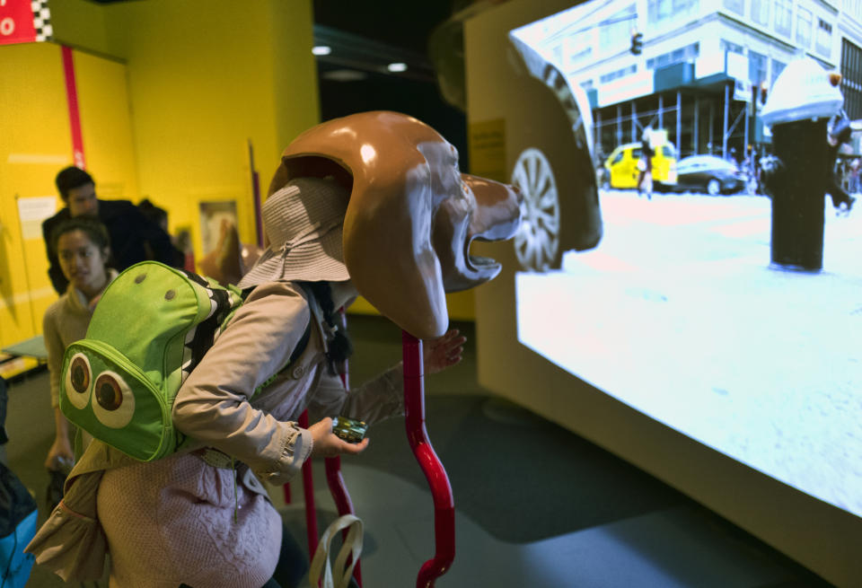 In this Tuesday, March 12, 2019 photo, a visitor takes part in an immersive experience showing visitors how dogs see from inside the head of a dog at the California Science Center in Los Angeles. A new exhibit at a Los Angeles museum examines the relationship between dogs and humans and explores why the two species seem to think so much alike and get along so well. "Dogs! A Science Tail” opens Saturday, March 16, 2019, at the California Science Center. (AP Photo/Richard Vogel)