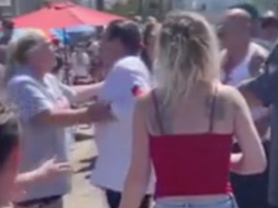 A woman at a Los Angeles Fourth of July parade tries to hold actor Danny Trejo back after he tried to punch a man who threw a water balloon at him (screengrab/Fox11)