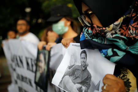 A woman holds a picture of a relative, one of the 189 people killed in a Lion Air plane crash, during a rally calling for Lion Air to put safety over profit and for Indonesian President Joko Widodo to ensure all remains were recovered, in Jakarta, Indonesia December 13, 2018. REUTERS/Darren Whiteside