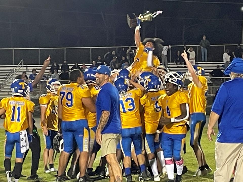 Titusville High football players celebrate with the US 1 Cup, awarded annually to the winner of the Terriers-Space Coast game. Titusville won, 40-0, on Tuesday, Oct. 4, 2022.