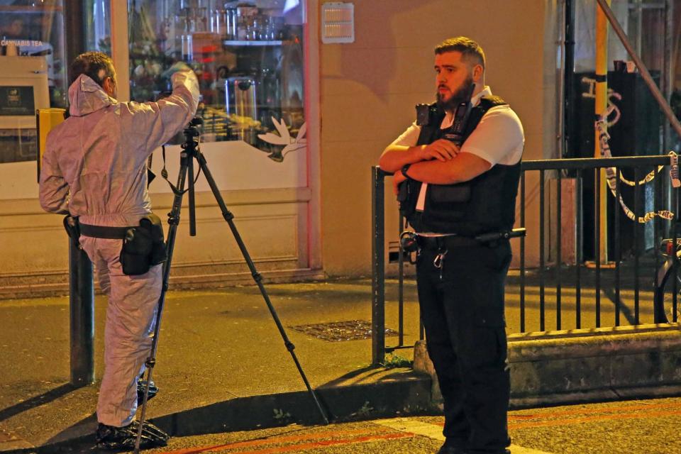 Police officers at the scene of the knife attack in north London (NIGEL HOWARD)
