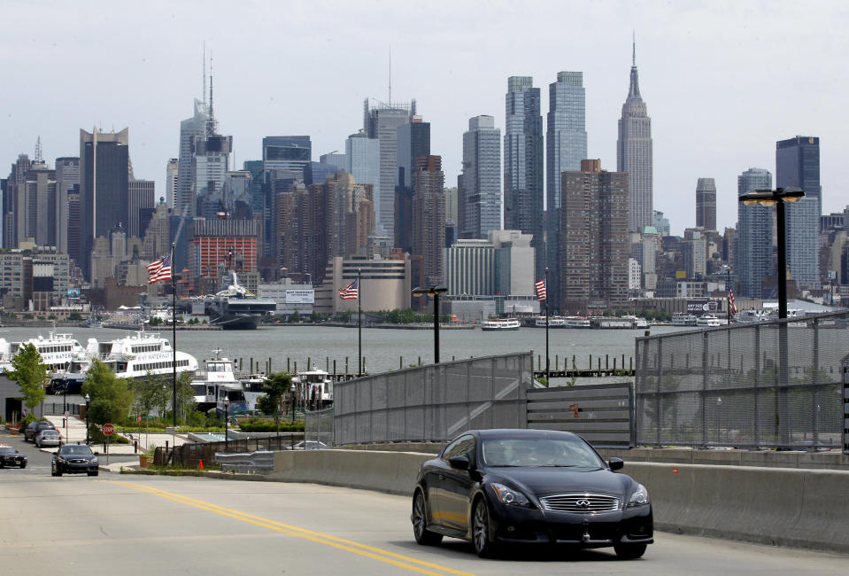 With the New York City skyline as a background, a vehicle driven by defending Formula One champion Sebastian Vettel climbs a hill, Monday, June 11, 2012, in Weehawken, N.J. Vettel drove a 3.2-mile course to demonstrate the planned route for next year's Grand Prix of America race. (AP Photo/Julio Cortez)