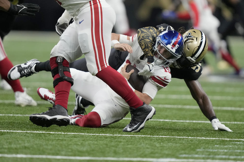 New York Giants quarterback Tommy DeVito (15) is sacked for an 8-yard loss by New Orleans Saints linebacker Demario Davis during the first half of an NFL football game Sunday, Dec. 17, 2023, in New Orleans. (AP Photo/Gerald Herbert)