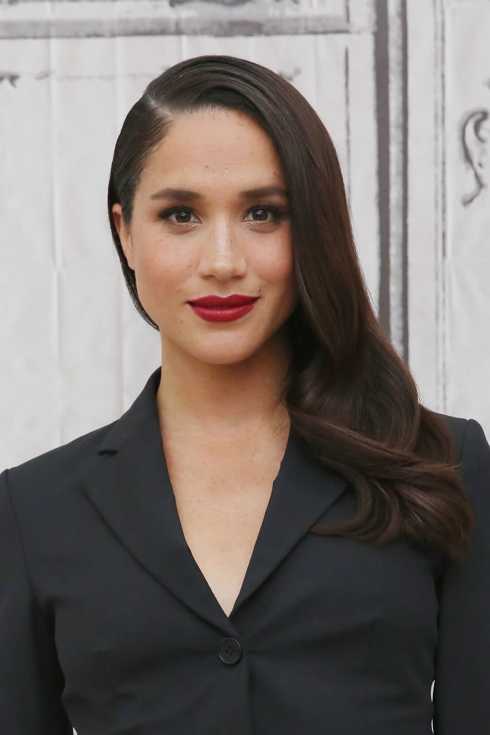 Meghan wearing red lipstick and side swept hair in 2016