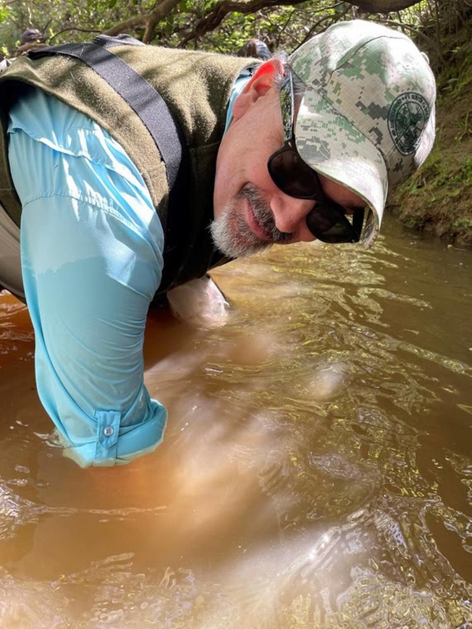 South Carolina Department of Natural Resources director Robert Boyles, Jr. places a Carolina Heelsplitter mussel into Flat Creek in Lancaster County.