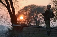 An Indian Border Security Force soldier keeps watch at an outpost along the India-Pakistan border in Abdulian, 38 kms southwest of Jammu, on January 9, 2013. India delivered a dressing-down Wednesday to Islamabad's envoy to Delhi as it accused Pakistan's army of beheading one of two soldiers killed in Kashmir, but both sides warned against inflaming tensions