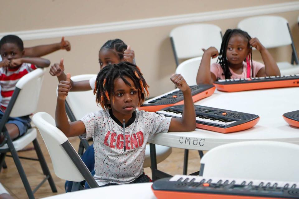 Students hold their thumbs up during DUETkids piano lessons at Central Missionary Baptist Church in Hitch Village.