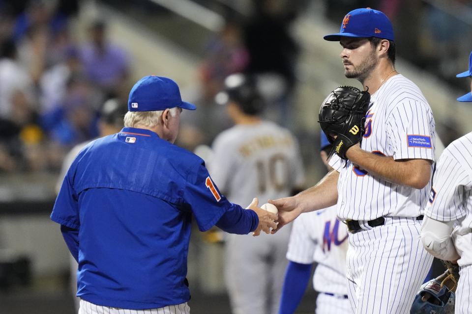 New York Mets relief pitcher Grant Hartwig, right, hands the ball to manager Buck Showalter as he leaves during the seventh inning of a baseball game against the Pittsburgh Pirates Tuesday, Aug. 15, 2023, in New York. (AP Photo/Frank Franklin II)