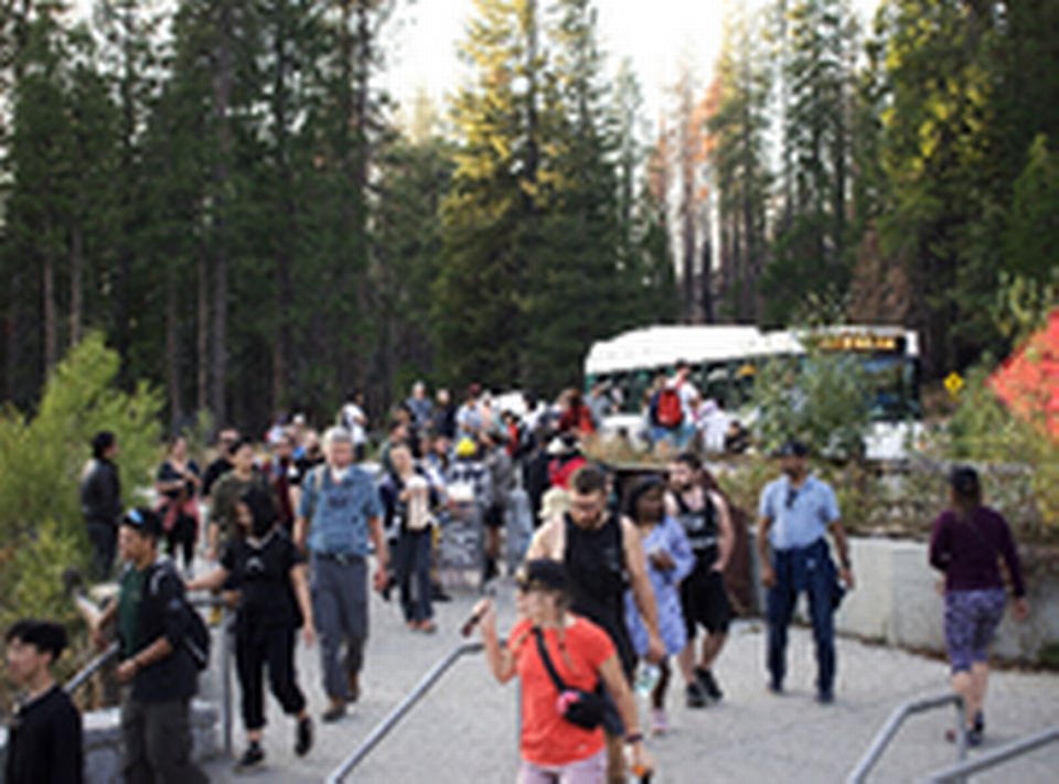 Dozens of tourists step out of a shuttle bus just inside Yosemite National Park’s south entrance. Visitors might not have access to services and facilities in the park if it closes.