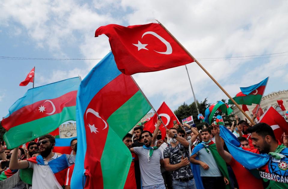 Azerbaijani men wave the flags of Turkey and Azerbaijan in Istanbul on 19 July, 2020. (REUTERS)