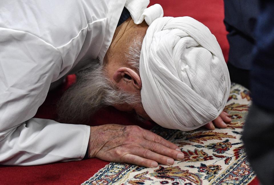 A muslim prays in a mosque for the victims of the shooting in Hanau, Germany, Friday, Feb. 21, 2020. A 43-year-old German man shot and killed several people of foreign background, most of them Turkish, on Wednesday night in an attack that began at a hookah bar. (AP Photo/Martin Meissner)