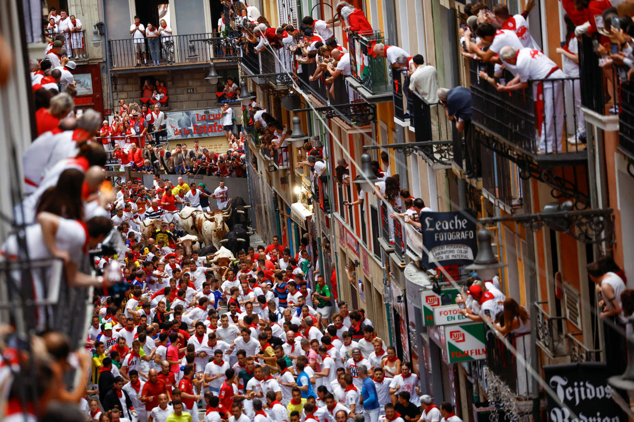 Revelers sprint through a street during the running of the bulls at the San Fermin Festival in Pamplona, Spain.