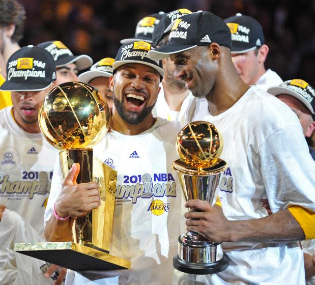 Los Angeles Lakers Derek Fisher (C) and MVP Kobe Bryant (R) hold the team and MVP trophies after winning Game 7 of the 2010 NBA Finals to clinch the Championship at Staples Center on June 17, 2010 in Los Angeles, California. The Lakers defeated the Celtics 83-79 for their 16th franchise title. AFP Photo/Paul J. Richards (Photo credit should read PAUL J. RICHARDS/AFP via Getty Images)