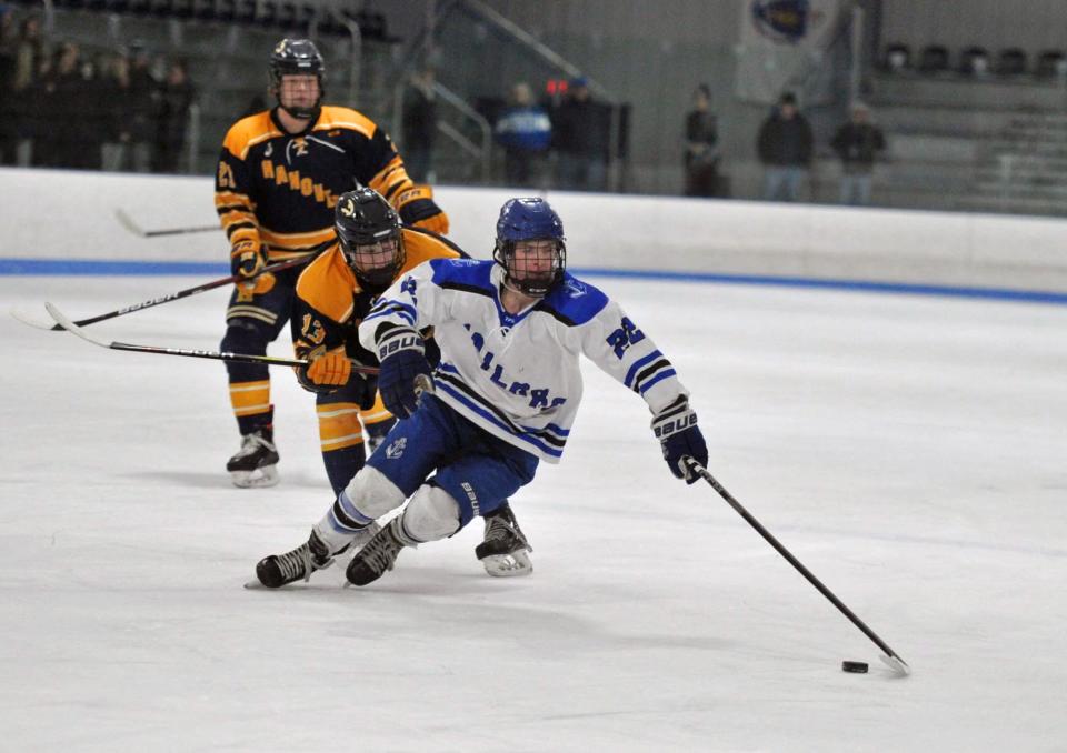 Scituate's Nate Sannella, right, gets control of the puck ahead of Hanover's Connor Hines, center, during boys high school hockey action at the Hobomock Arena in Pembroke, Wednesday, Feb. 7, 2024.