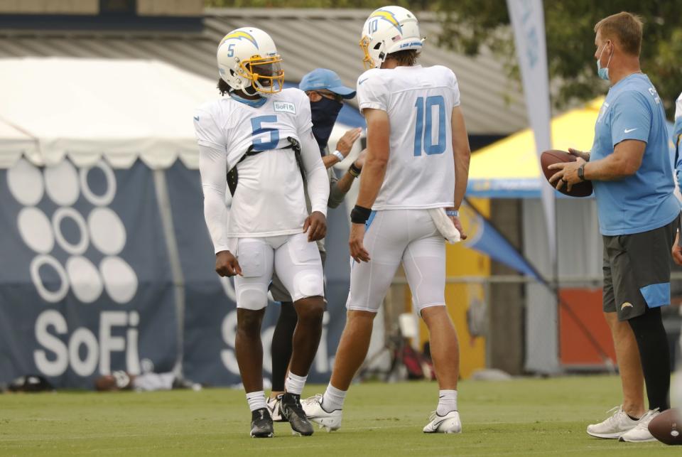 Chargers quarterback Justin Herbert works with quarterback Tyrod Taylor.