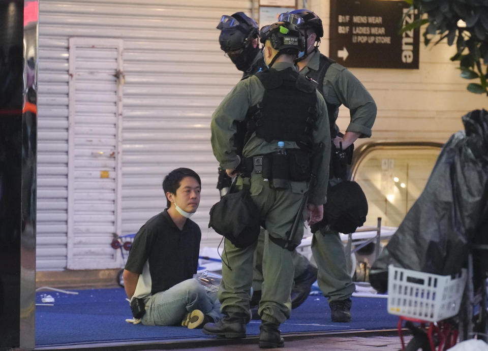 Hui Chi-fung, left, a Democratic Party politician detained by riot police during a protest in Causeway Bay, Hong Kong, Friday, June 12, 2020. Protesters in Hong Kong got its government to withdraw extradition legislation last year, but now they're getting a more dreaded national security law, and the message from Beijing is that protest is futile.(AP Photo/Vincent Yu)